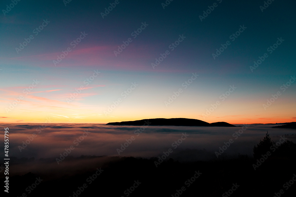 Sunset seen from the top of the mountain in a sea of ​​clouds