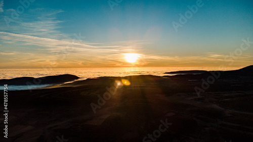 Aerial view of a sea of ​​clouds between the mountains during sunset