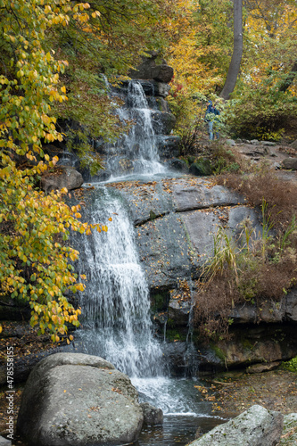 Distant view of  waterfall in forest. Autumn