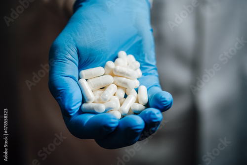 Medical professional's hand holding white pills