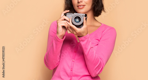 Woman photographer crop view holding photo camera in hands beige background, photographing © be free