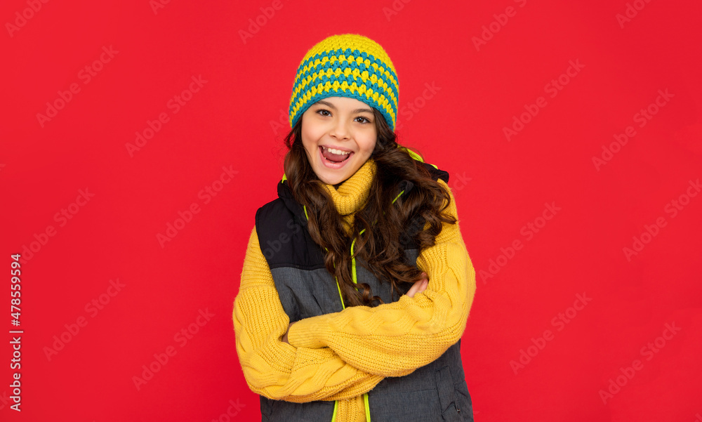 winter fashion. emotional happy kid with curly hair in hat. teen girl on red background. winter fashion. emotional happy kid with curly hair in hat. teen girl on red background.