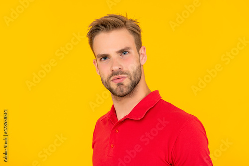 face of man in red shirt on yellow background, skincare