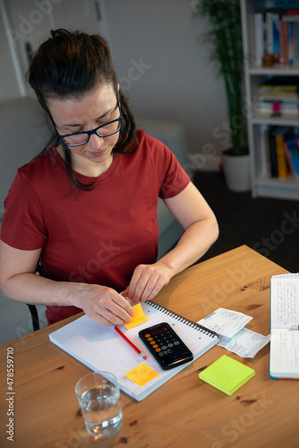 Small business owner doing paperwork in a casual home office environment