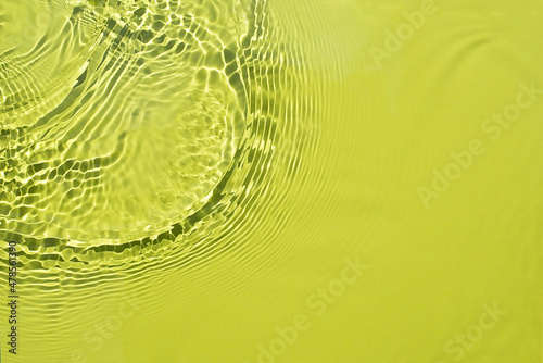 Water spills on a light green yellow background. Natural sunlight and shade. Beautiful bursts and glare. Summer mood. Minimal style.