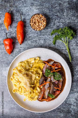 tenderloin sautéed with pasta onion corn mote on gray marble