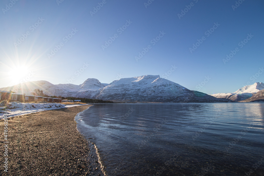 Breathtaking wildlife of the northernmost part of Norway, Finnmark in the small village of Skibotn. The snow-capped hills of the Lyngen alps along with the sea and the sunset. Scandinavian landscape