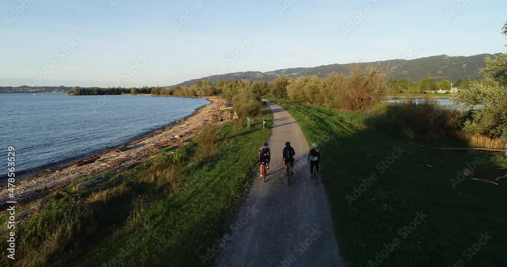 Aerial view of three person cycling a bike along Constance lake, Switzerland. Aerial view of three person cycling a bike along Constance lake, Switzerland.