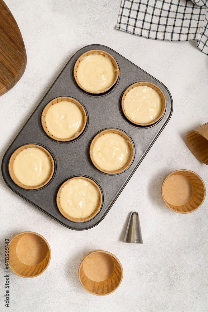 cupcake mold with dough on the grey background. Vertical frame. cupcake mold with dough on the grey background. Vertical frame.