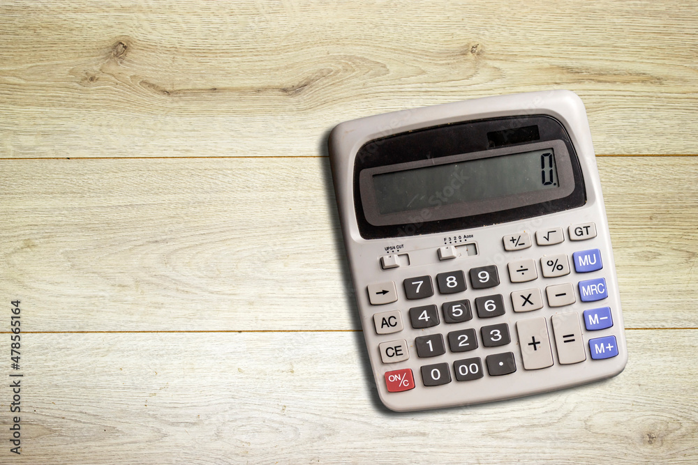 gray big calculator isolated on wood table gray big calculator isolated on wood table
