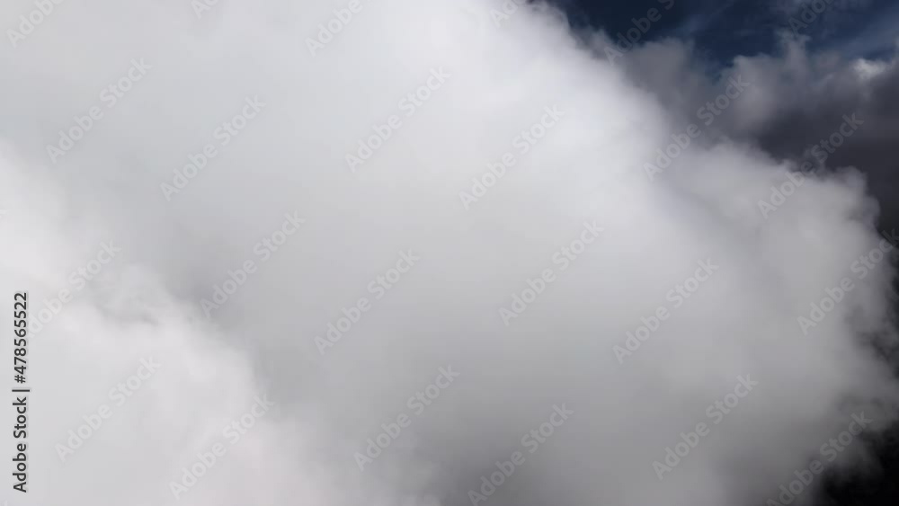Aerial view from airplane window at high altitude of earth covered with puffy cumulus clouds forming before rainstorm