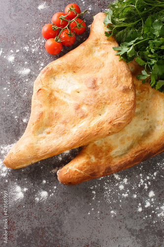 Shotis puri or simply shoti is a type of traditional Georgian bread made of white flour and shaped like a canoe close up on the table. Vertical top view from above photo