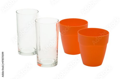 Dois copos de vidro e dois copos de plástico laranja em fundo branco (ID: 478570399)