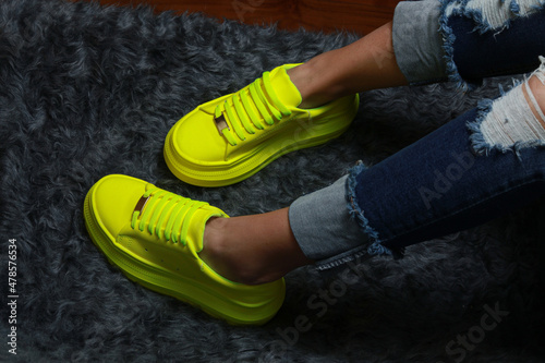 Fluorescent green women's tennis shoes on a black background photo