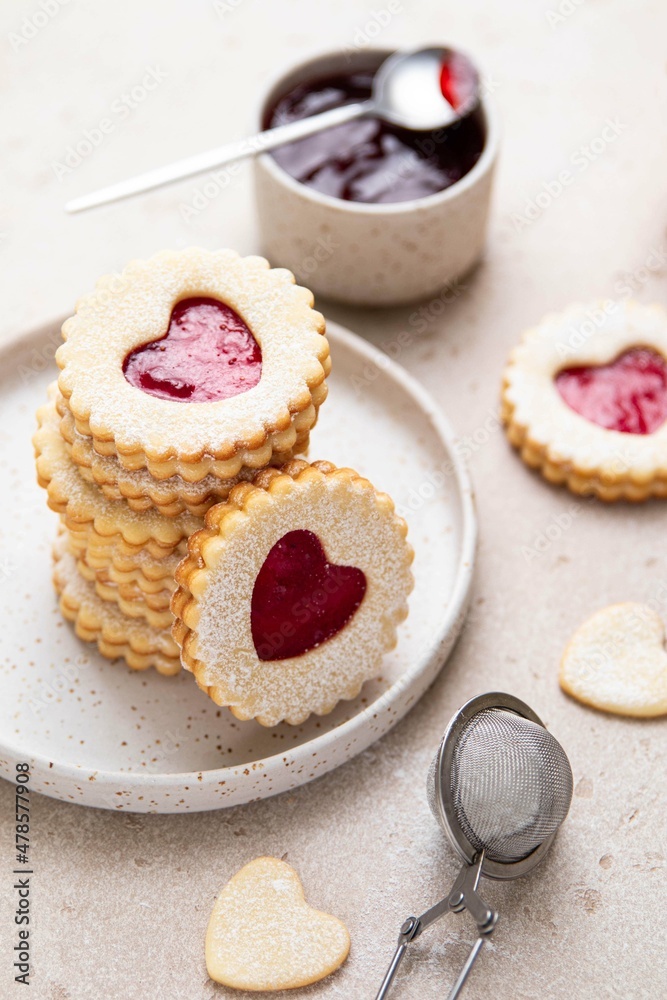 Linzer cookies in shape of heart with jam on light background. Mother's day, Women's day, Valentine's day. Homemade present. Selective focus. Linzer cookies in shape of heart with jam on light background. Mother's day, Women's day, Valentine's day. Homemade present. Selective focus.