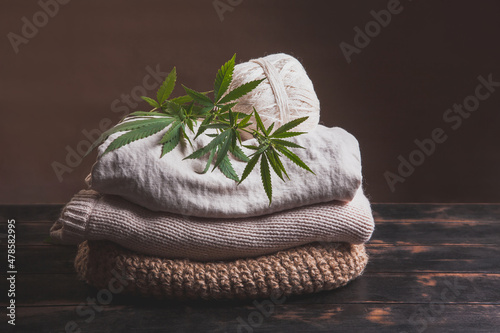 Obraz na płótnie A stack of various types of hemp fiber fabrics. Hemp threads, yarn and fabric with cannabis leaves on a wooden background w salonie