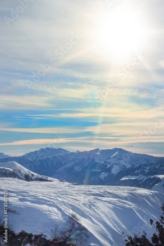View of the snowy mountain range, Georgia. Landscape. High mountains under snow on a sunny day. Panorama of the white mountains in the snow with a beautiful sky