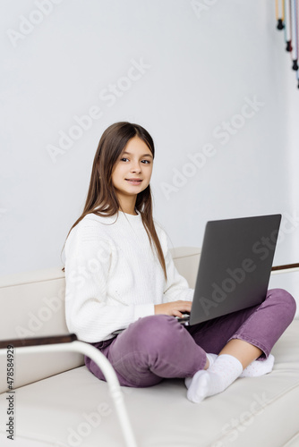 Cute girl sitting on sofa with laptop at home © F8  \ Suport Ukraine
