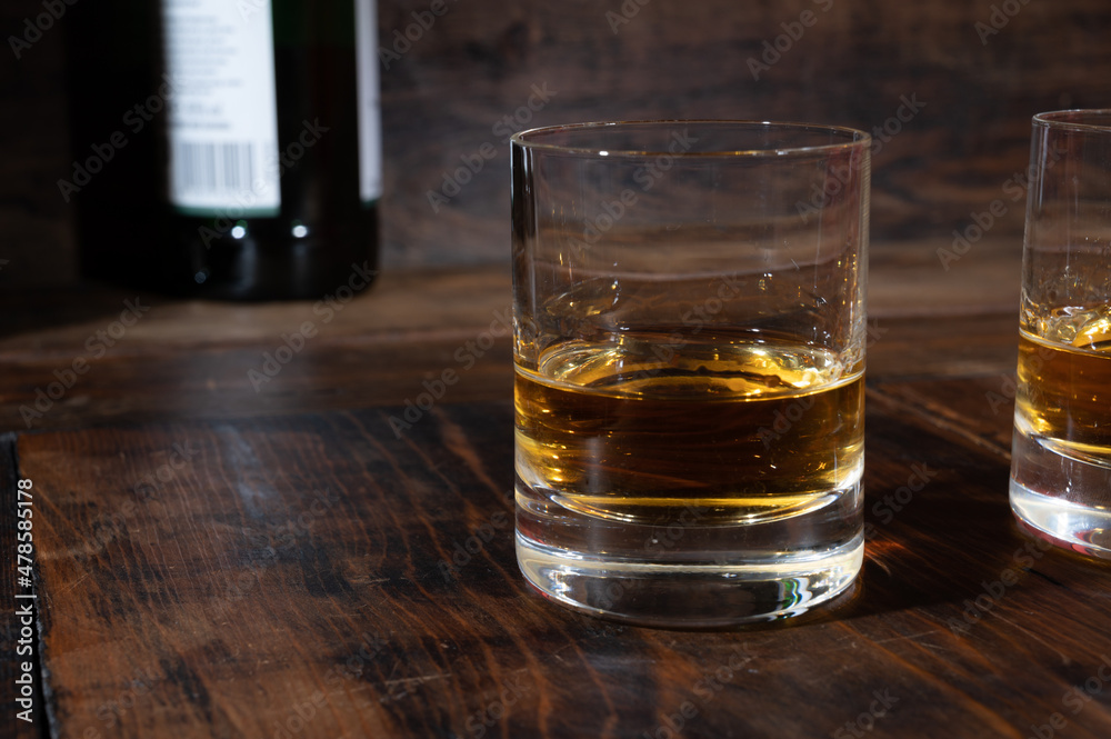 Glasses of strong scotch single malt whisky served on dark wooden table in old pub Glasses of strong scotch single malt whisky served on dark wooden table in old pub