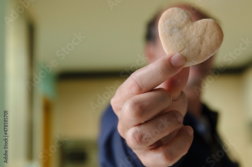 Man holding heart cookie, in love on valentine's day