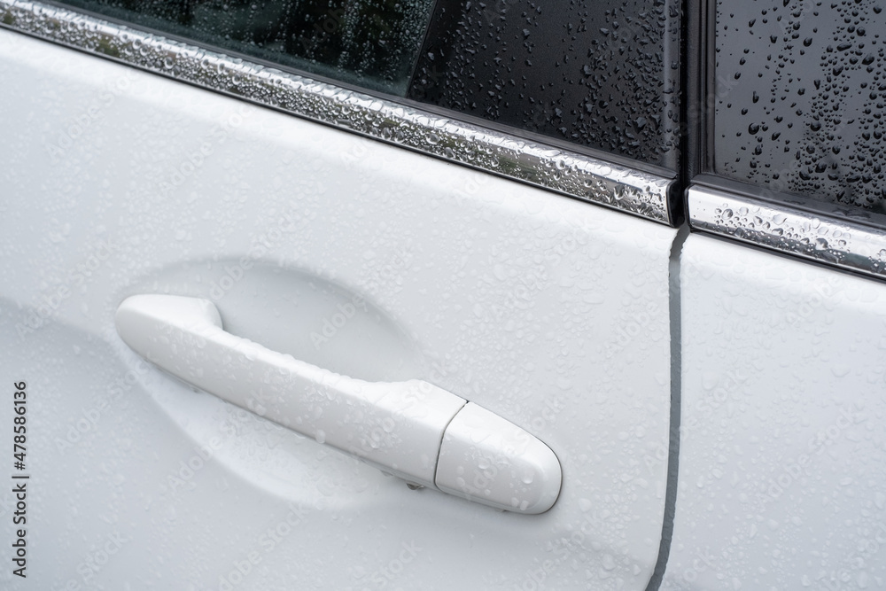 Car door handle and side window were covered raindrops. Transportation in the wet Autumn season. Car door handle and side window were covered raindrops. Transportation in the wet Autumn season.