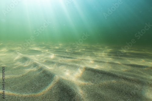 Fotografia Natural underwater seascape, sand on the sea floor and water surface with sunlight
