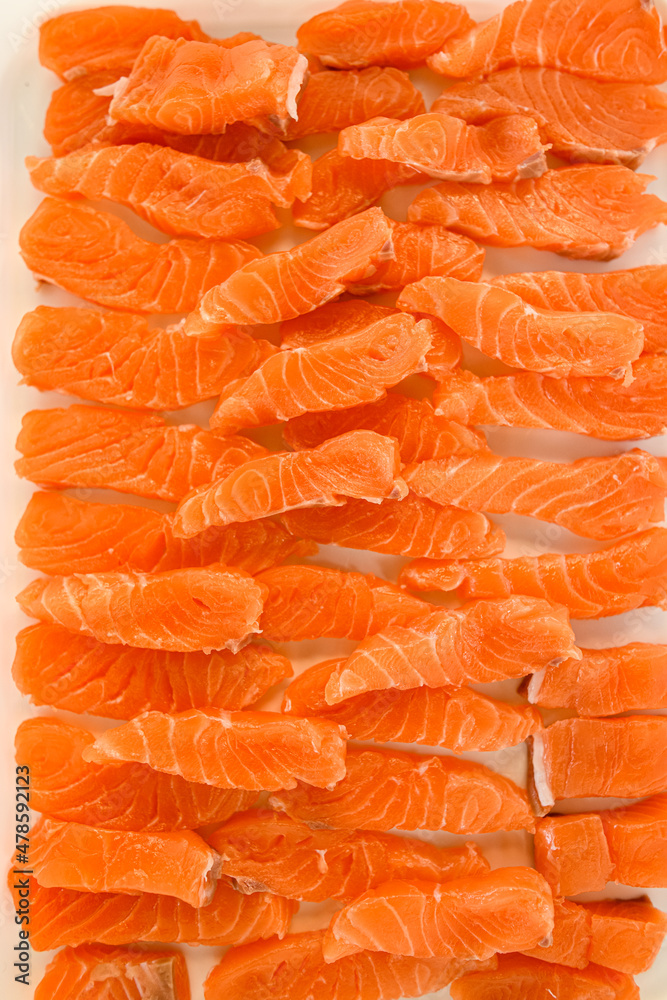 Top view of many pieces of fresh raw salmon fillet on parchment Top view of many pieces of fresh raw salmon fillet on parchment