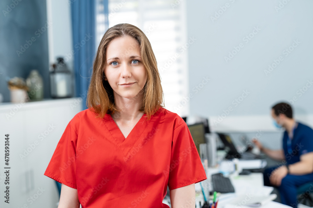 Attractive female doctor looking into camera. Pretty young doctor posing for camera. Stock photo