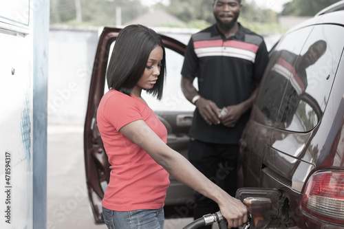 african filling station attendant filling up a car © Confidence