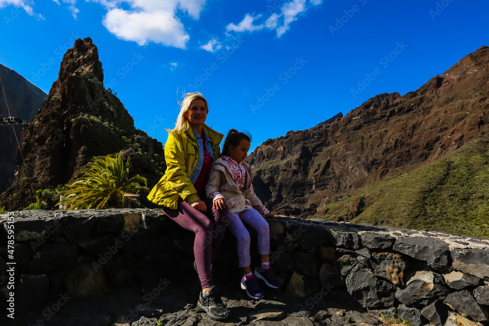 family travel- mother and daughter hiking in scenic mountains.