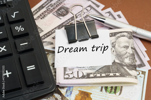Fotografie On a brown background lies a calculator and dollars on a clip with an inscriptio