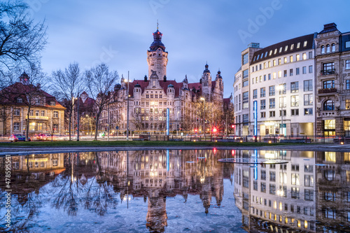 Foto Cityscape of Leipzig (Germany) with the New Town Hall, seat of the city administration since 1905, reflecting at the blue hour in the water of a fountain