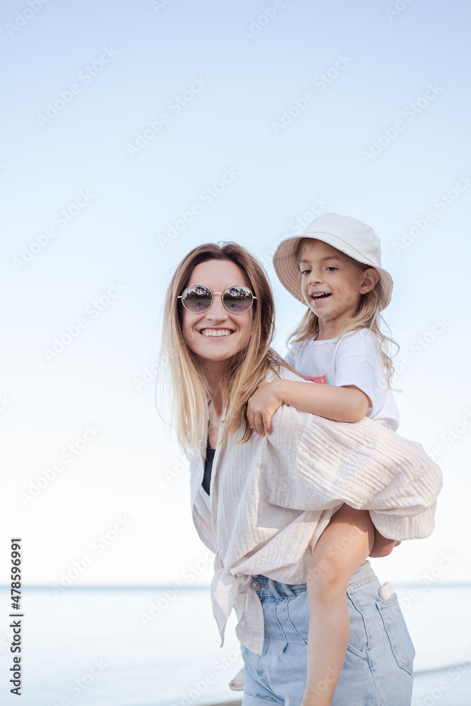 beautiful mom and her daughter at seaside smiling and have fun. Lovely family lifestyle concept.