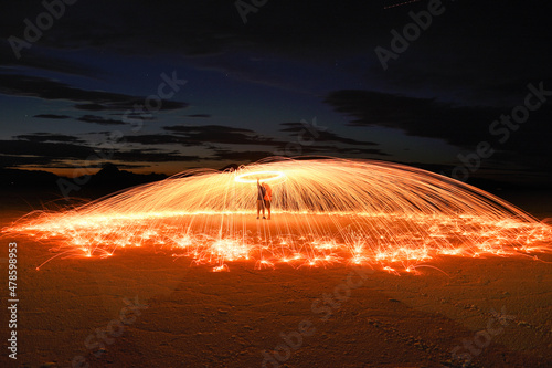 Long exposure photography of two people under a sparkling umbrella made using spinning burning steel wool
