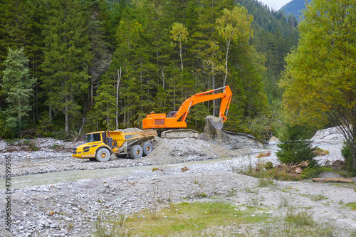 Flussregulierung mit einem Schaufelbagger, in den österreichischen Alpen, im Obersulzbachtal, Salzburger Land. photo