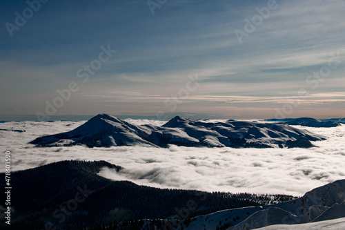 marvelous aerial view of snow covered mountain top and picturesque winter mountain landscape with coniferous trees and fog