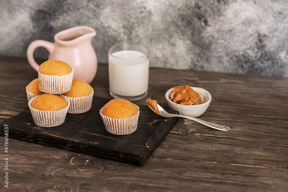 Freshly baked fresh muffins. jug and glass of milk on a wooden table. Portion cupcakes, sweet Freshly baked fresh muffins. jug and glass of milk on a wooden table. Portion cupcakes, sweet