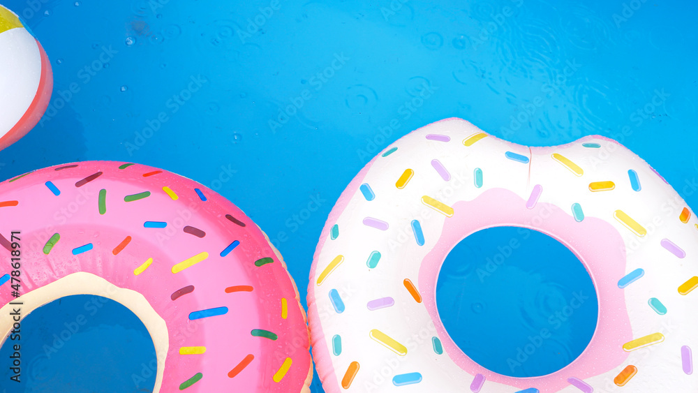 TOP DOWN: Inflatable donuts float around the empty home pool during a rainstorm. TOP DOWN: Inflatable donuts float around the empty home pool during a rainstorm.