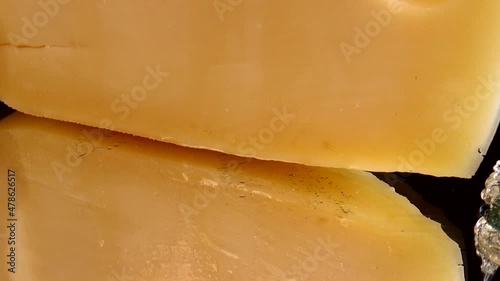 Drops of honey flow down from the cheese on a mirrored black background. photo