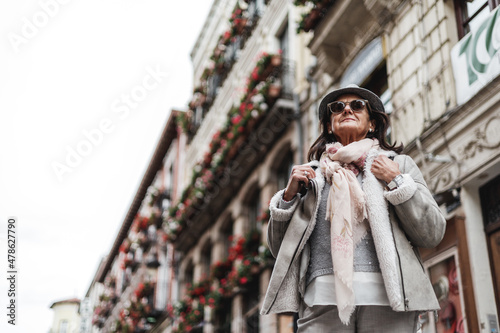 view from above of mature hispanic woman in fashion with hat and sunglasses in the street