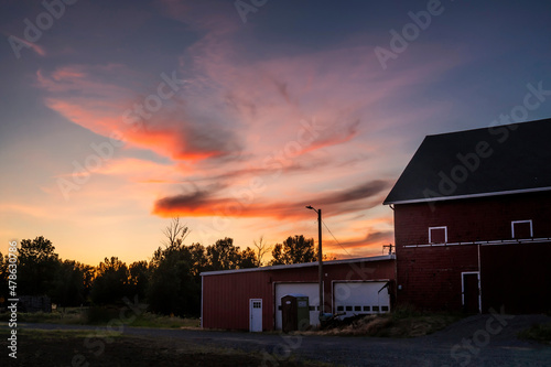 A sunset over a country side barn