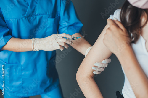 Close up portrait of Doctor's hands making a vaccine in the shoulder of patient. Adult immunization, covid vaccine. Antiviral injection. Medical treatment.