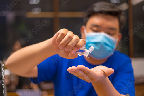 Close up hand sanitizer man applying sanitizing gel liquid rubbing hands clean personal hygiene coronavirus pervention at home. Sanitiser bottle. photo