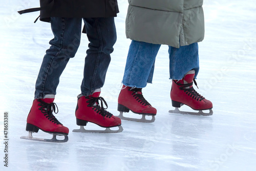 Ice skating on an ice rink. legs with skates. Winter active sport and leisure hobby.