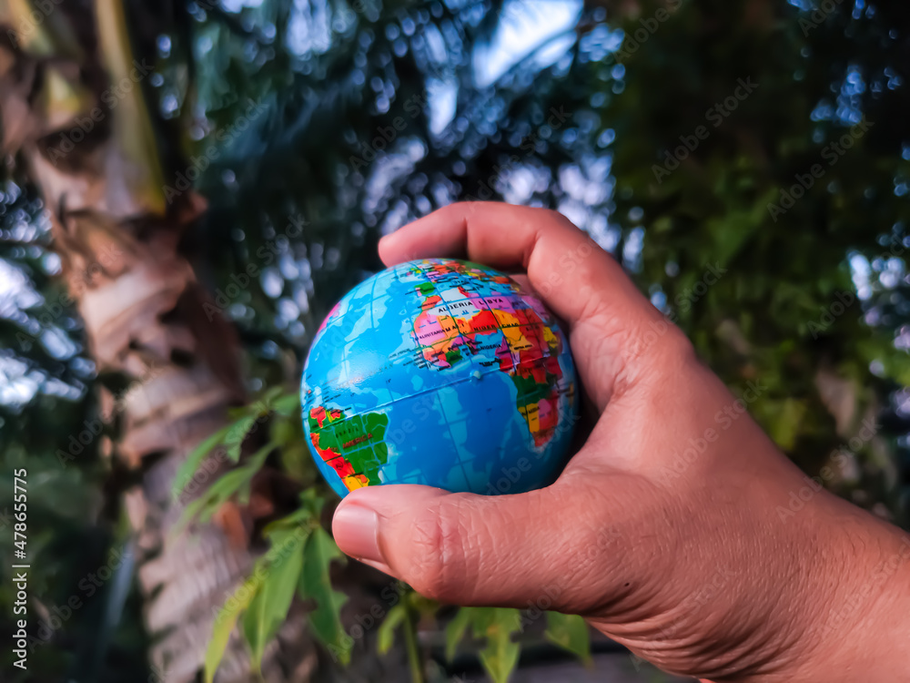 Hand holding world globe with blurred green nature background. Hand holding world globe with blurred green nature background.