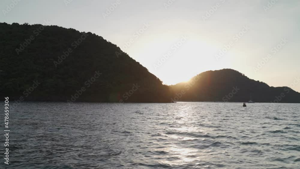 sea water ripples wave in ocean during sunset twilight dawn. boat sail passing island. background with copy space. seascape evening. sea water ripples wave in ocean during sunset twilight dawn. boat sail passing island. background with copy space. seascape evening.