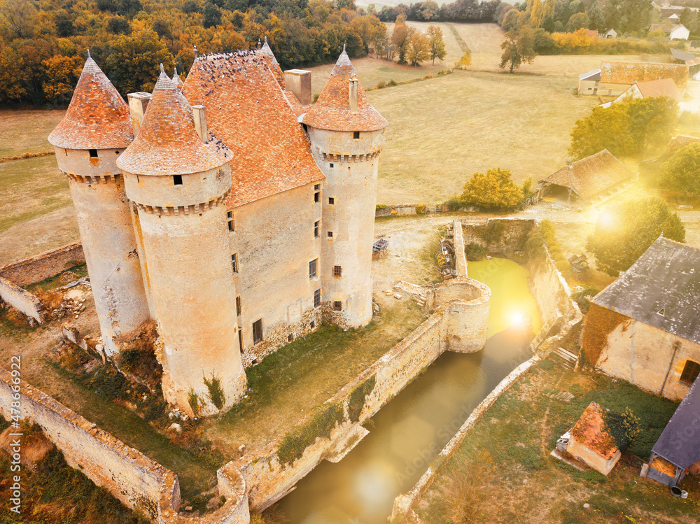 Picturesque autumn landscape with imposing medieval fortress Chateau de Sarzay, France..