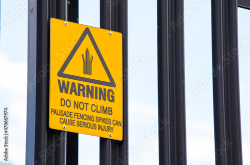 Warning sign for do not climb palisade fencing spikes can cause serious injury. photo