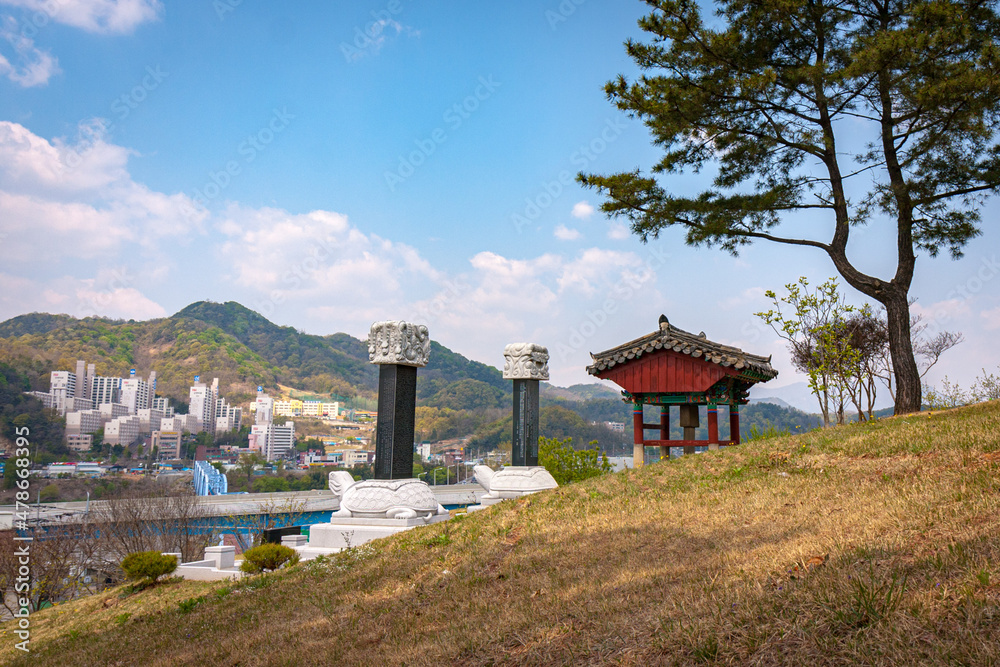 Oriental pagoda and turtle pillars on hill outlook with view of cityscape in the mountains in South Korea Oriental pagoda and turtle pillars on hill outlook with view of cityscape in the mountains in South Korea