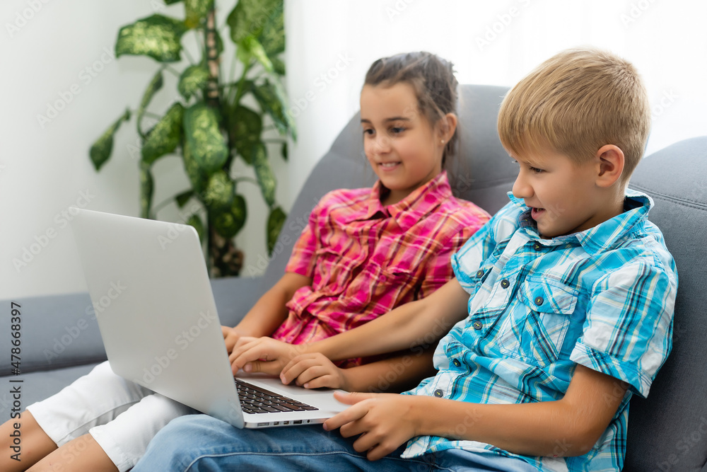 Cute children use laptop for education, online study, home studying, Boy and Girl have homework at distance learning. Lifestyle concept for home schooling.